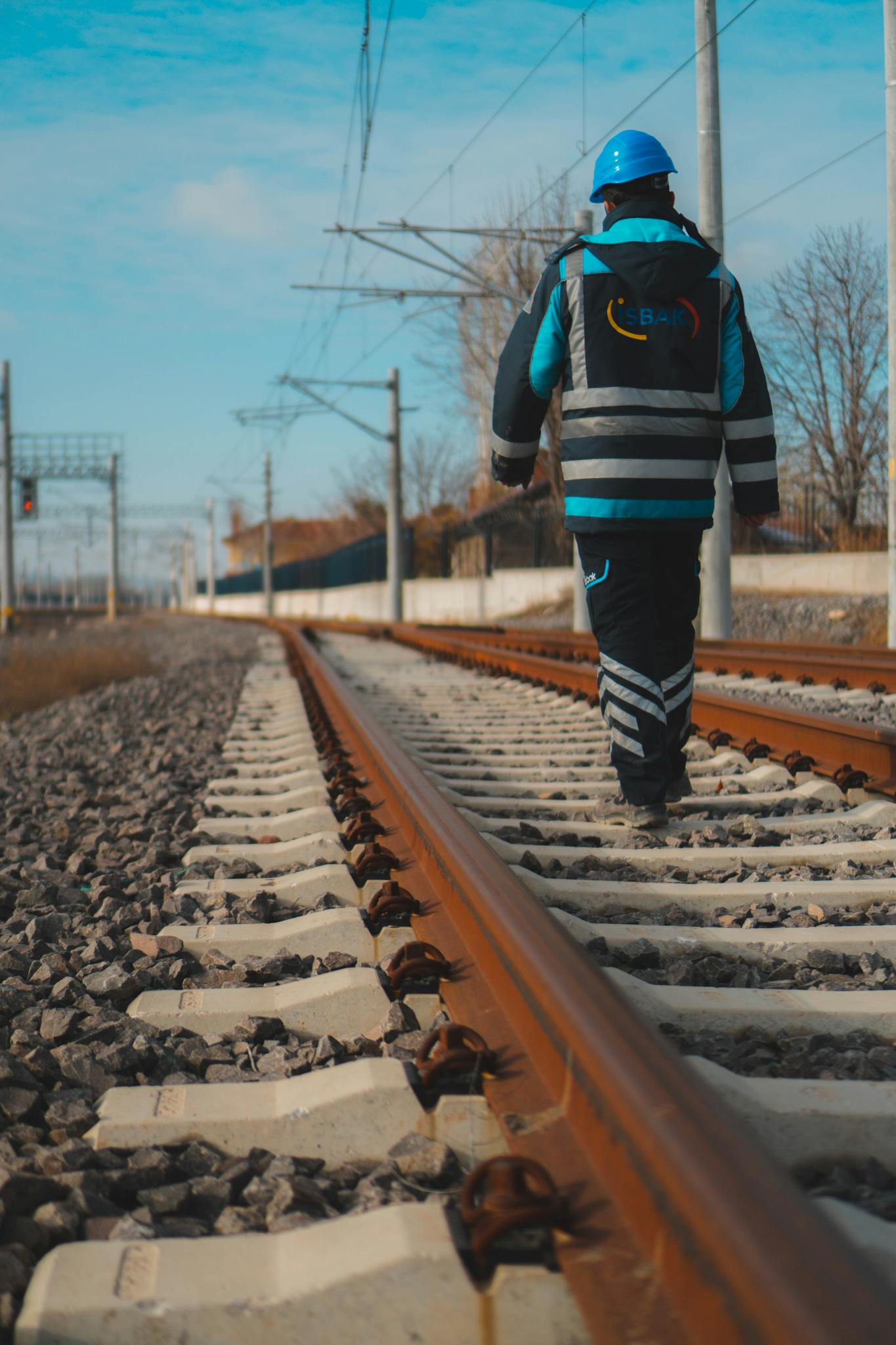 A construction worker in safety gear walking on railway tracks in Eskişehir, Turkey.